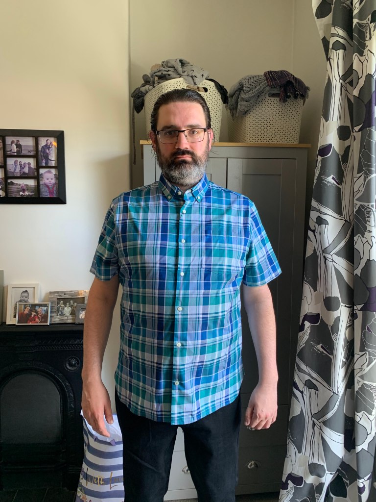 A picture of me, looking at the camera, standing in my house.