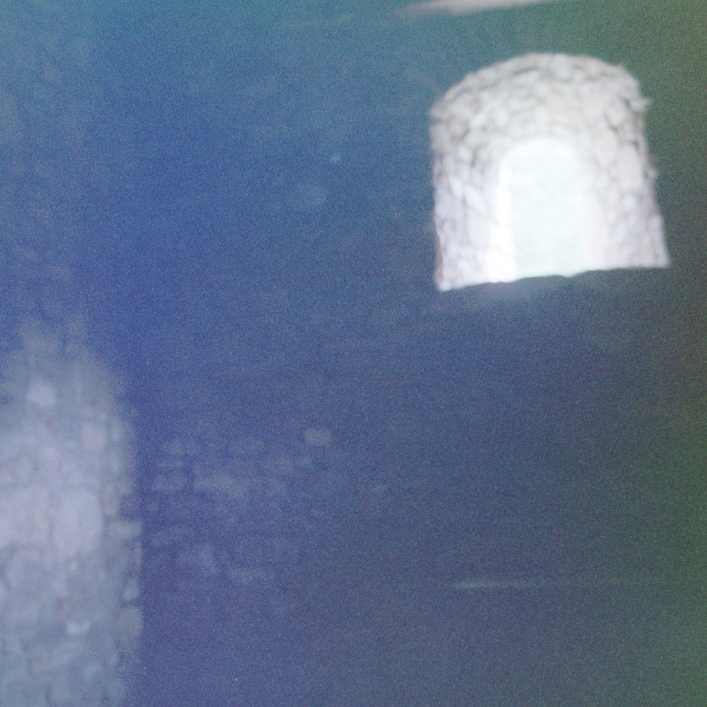 The wall of a ruined church, with a high window